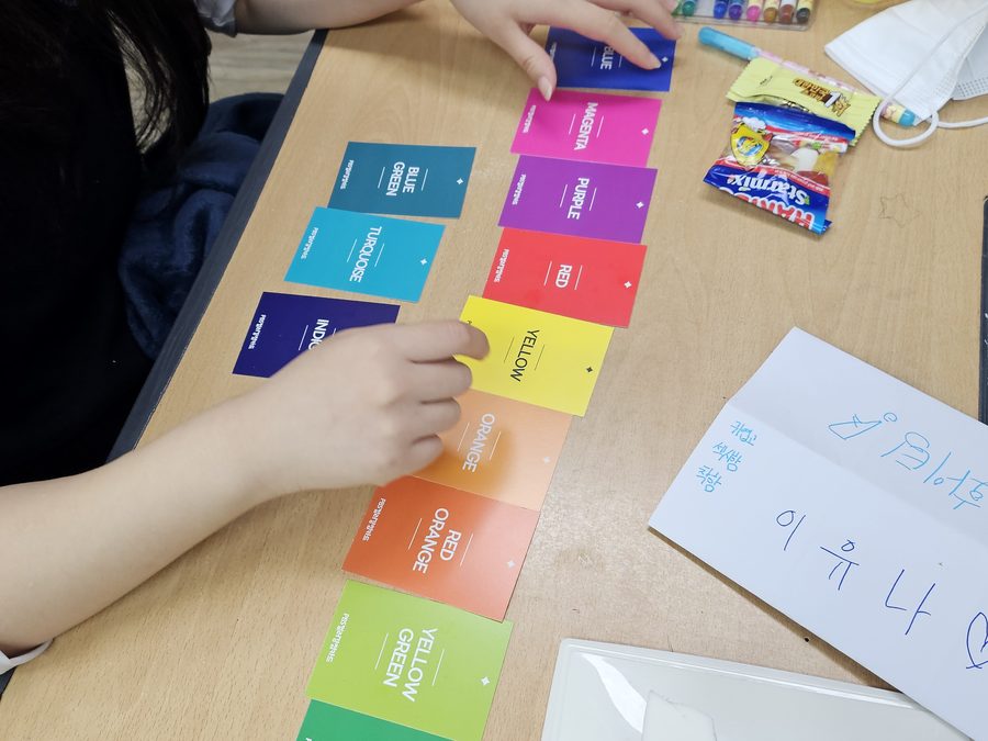 컬러 카드를 나란히 늘어놓고 이야기를 나누는 장면