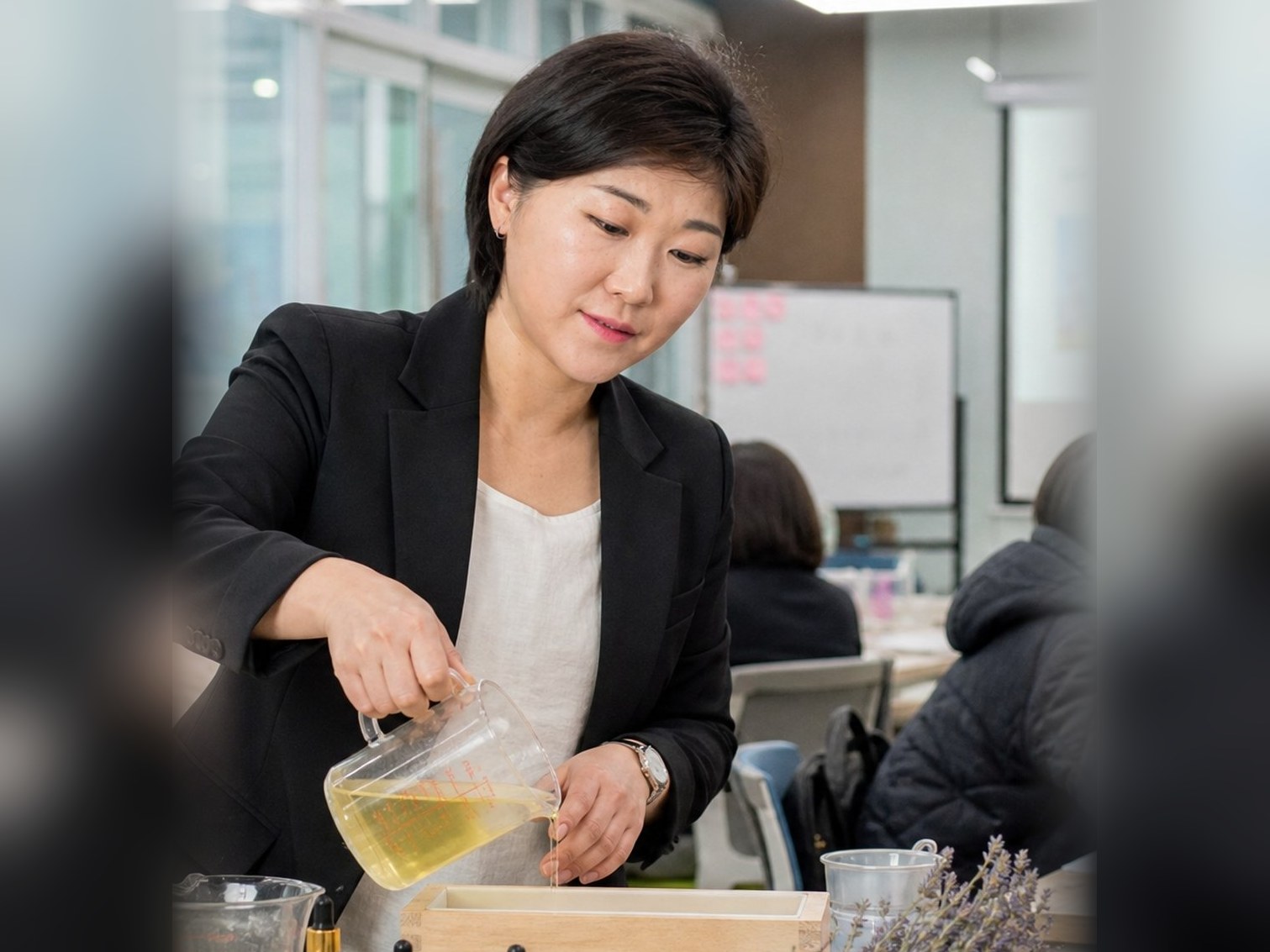 교사연수에서 강사가 천연비누액을 몰드에 붓는 시범을 보이는 모습